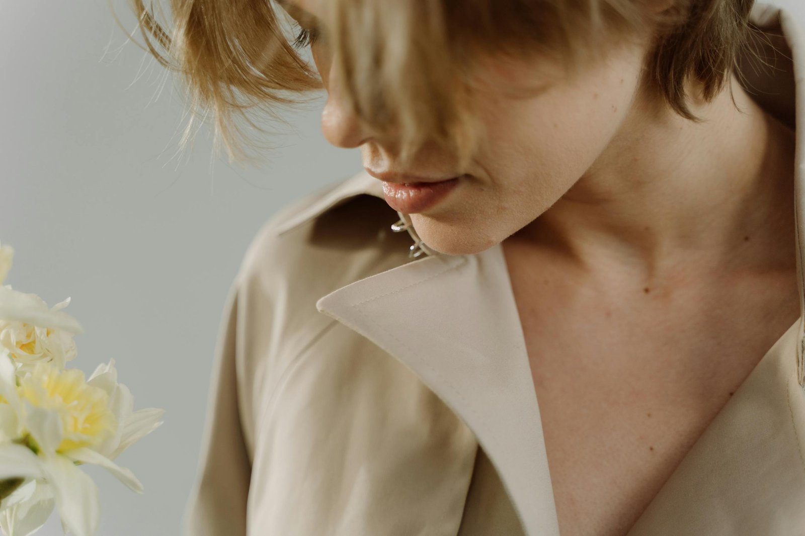 Close-up portrait of a woman in a beige blazer, emphasizing elegance and subtlety.