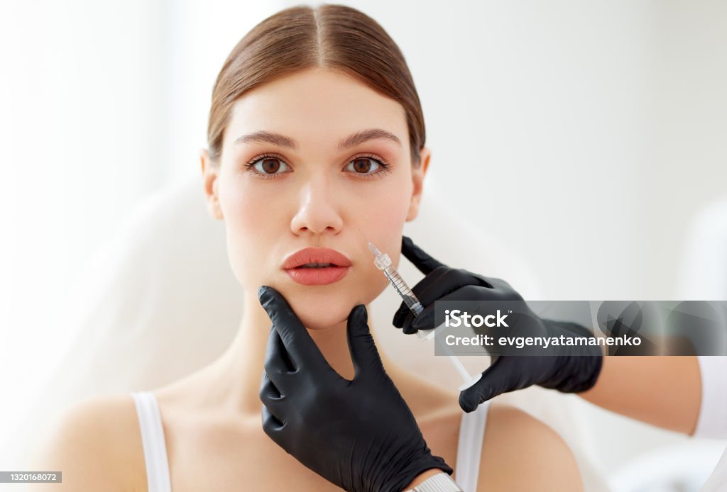 Woman happily touching her smooth lips after reducing stubborn swelling from fillers fast
